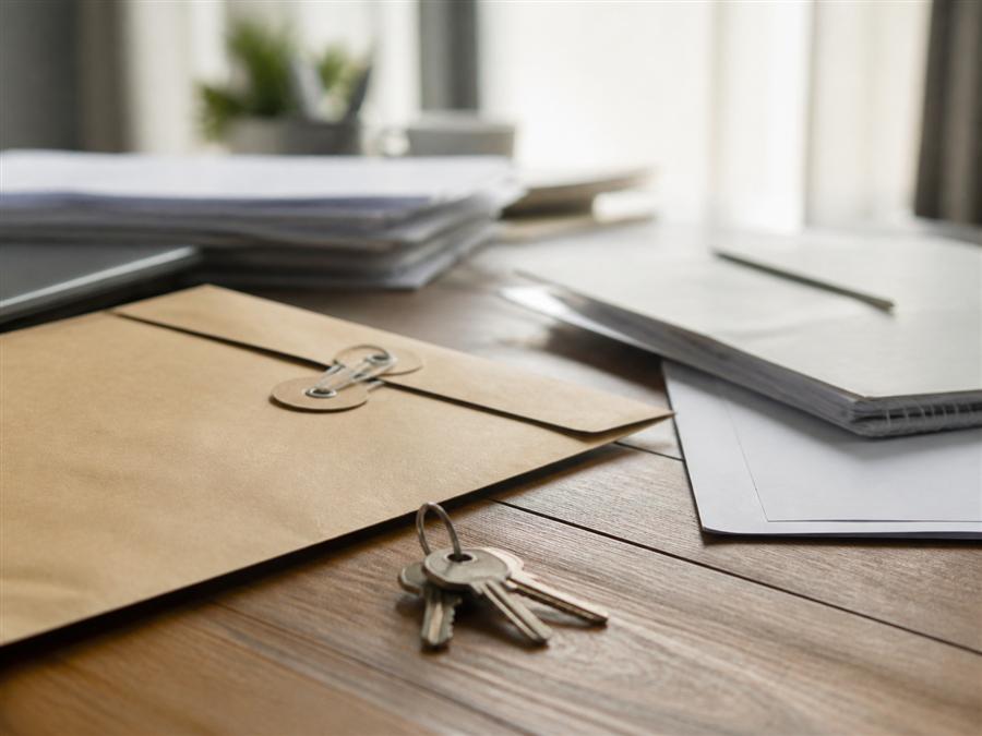 Documentos e chaves sobre mesa de trabalho